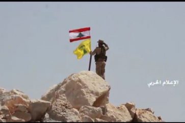 Un combattant hisse le drapeau du Liban et du Hezbollah sur une des positions d'al-Nosra dans le Jurd d'Ersal