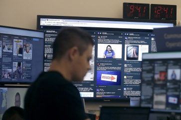 A man works at his desk in front of monitors during a demonstration in the war room, where Facebook monitors election related content on the platform, in Menlo Park, Calif., Wednesday, Oct. 17, 2018. (AP Photo/Jeff Chiu)