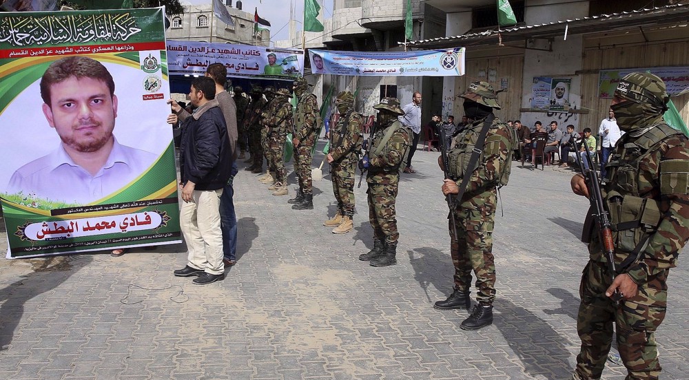 Des membres des brigades Qassam tiennent un portrait du martyr al-Batsh à Gaza.