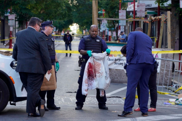 Des inspecteurs de police sur la scène de crime de South Street, à Philadelphie, le 5 juin 2022. © Michael Perez, AP