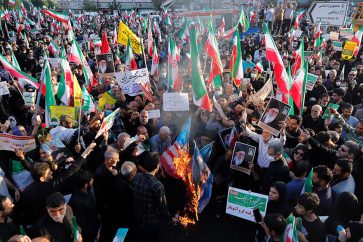 Des manifestants iraniens brulent les drapeaux israéliens et américains le 25 septembre 2022.