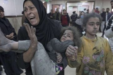Une femme palestinienne porte sa fille blessée par les bombardements israéliens contre Gaza.