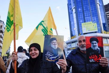 Des Libanais brandissent des drapeaux du Hezbollah et des affiches avec des images de l’ancien secrétaire général du Hezbollah, Seyyed Hassan Nasrallah, à l’entrée de la banlieue sud de Beyrouth, mercredi 27 novembre 2024. ©Reuters