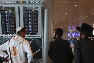 Des Israéliens vérifient l'horaire des départs à l'aéroport Ben Gourion de Tel Aviv le 29 septembre 2024. ©Getty Images